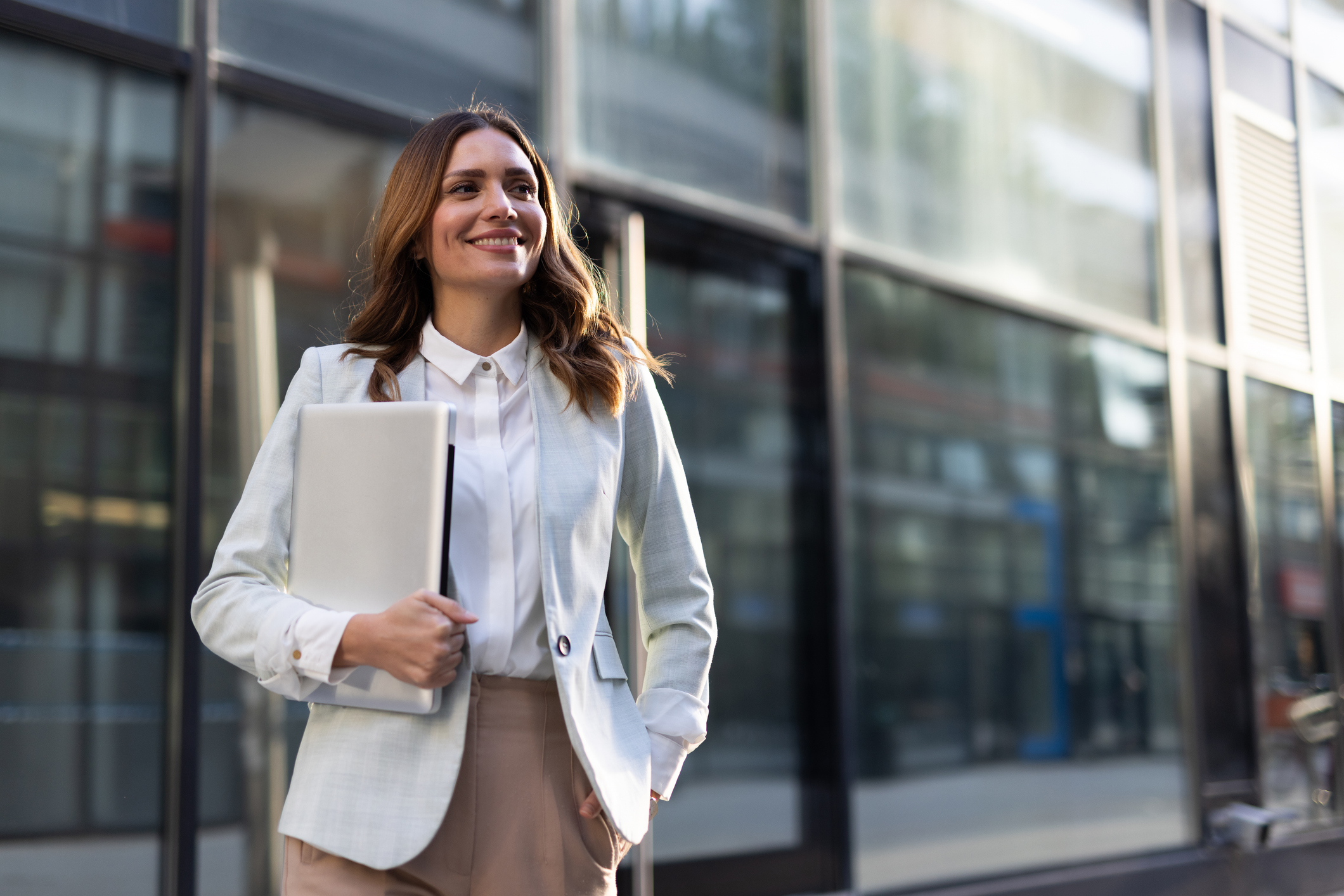 Woman walking with a computer in her arms