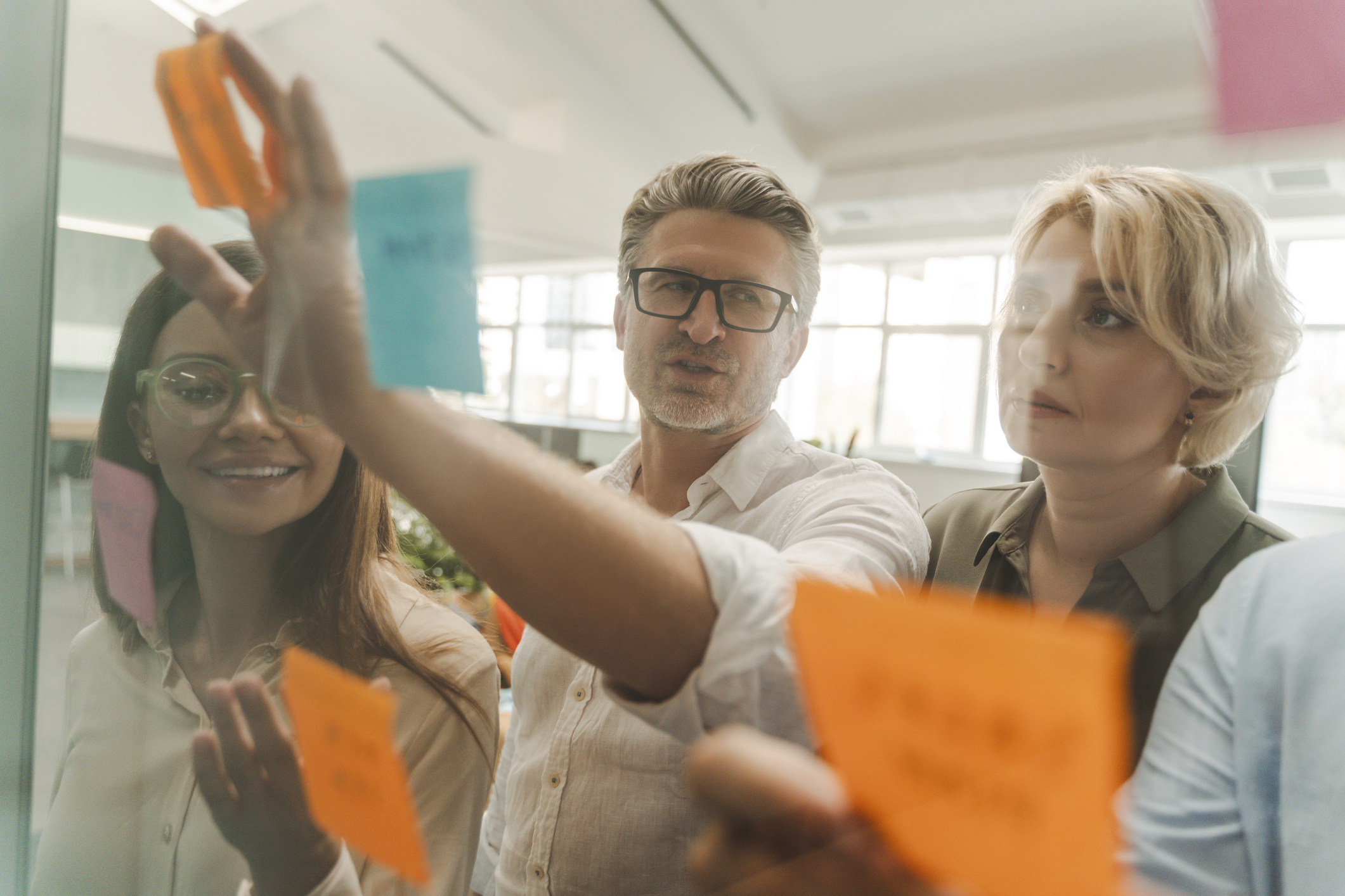 Colleagues writing on post-it notes.