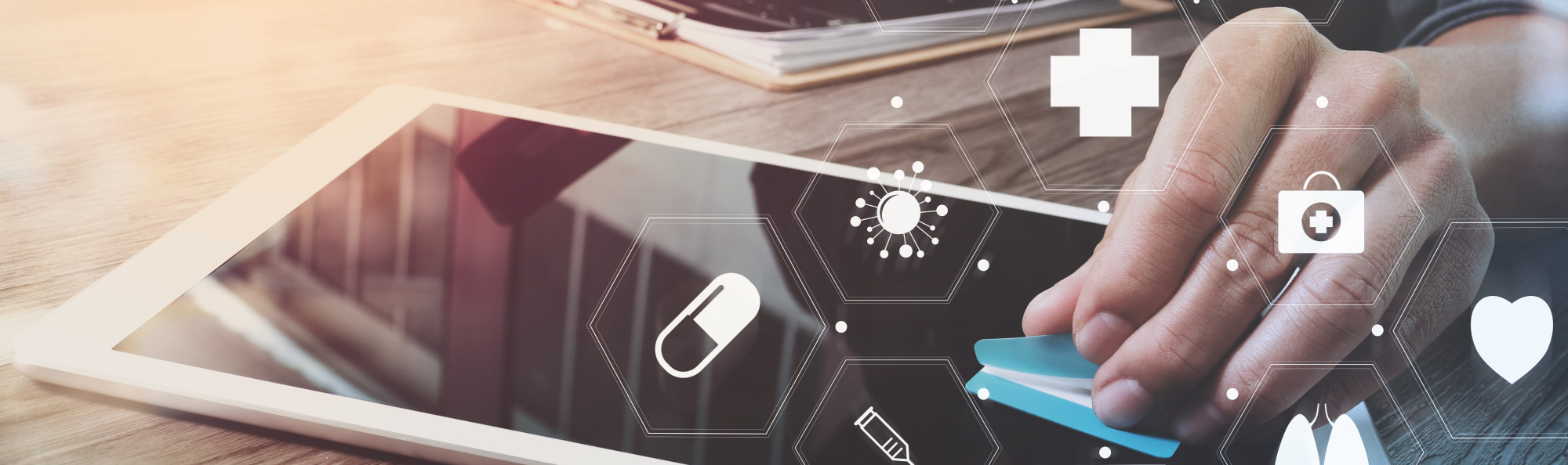 A hand uses a tablet, surrounded by digital health icons such as pill, heart and first aid – symbols of digital health technology. Photo: Colourbox