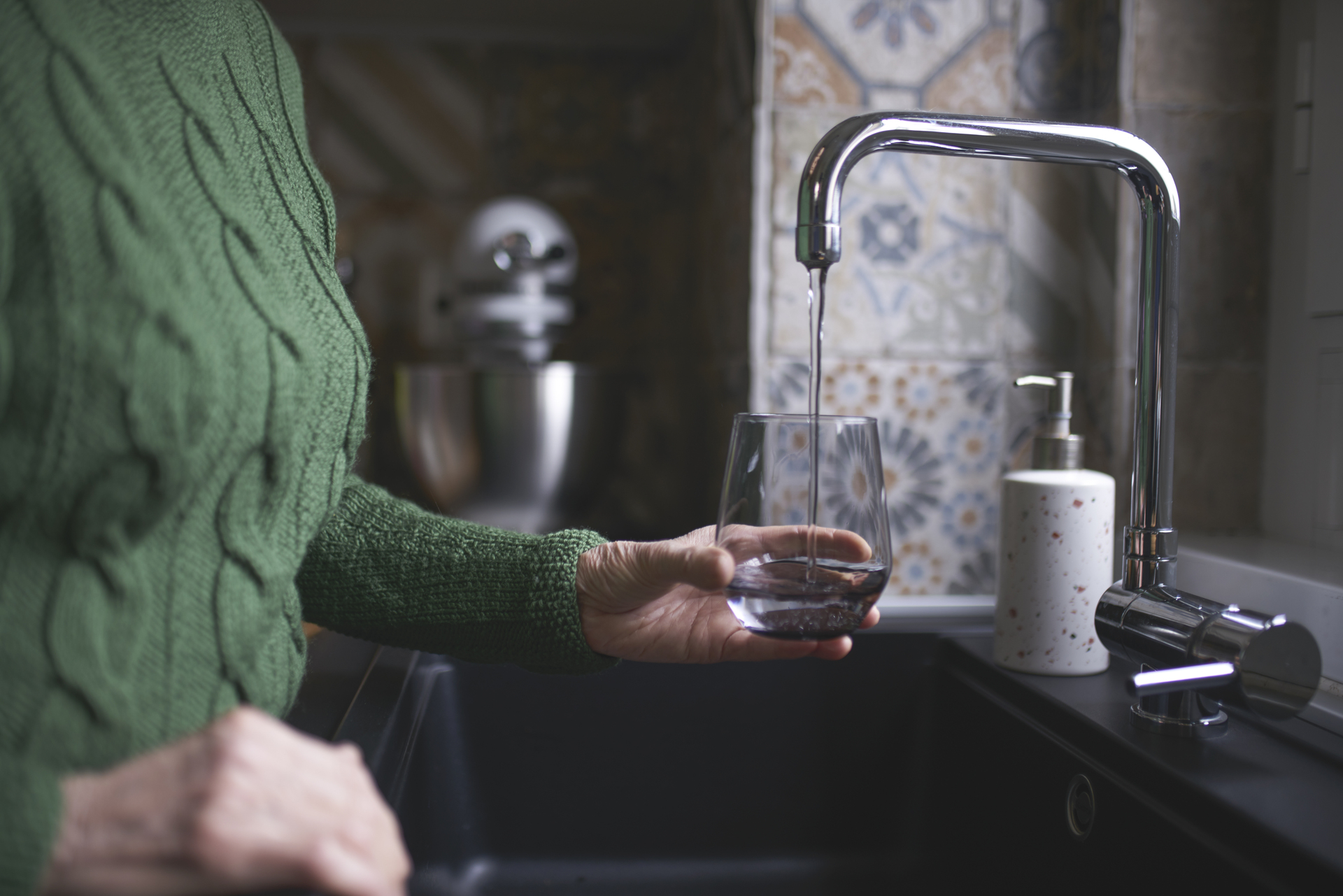 Image of a person filling tap water into a glass